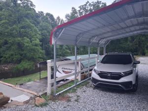 a suv parked under a garage with a boat at Camper with Queen and bunk bed in Robbinsville