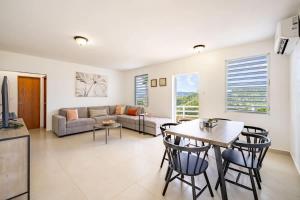 a living room with a couch and a table and chairs at Casa Brisa with Heated Pool Mountain View & River in Las Marias