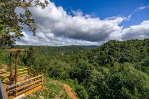 a wooden bench on top of a hill with trees at Casa Brisa with Heated Pool Mountain View & River in Las Marias
