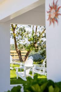 a group of white chairs sitting in the grass at Casa Brisa with Heated Pool Mountain View & River in Las Marias +64 photos