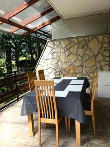 a table and chairs on a patio with a stone wall at Fehér Villa in Kővágóörs