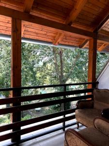 a screened in porch with two chairs and a large window at Fehér Villa in Kővágóörs