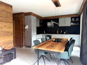 a kitchen and dining room with a wooden table and chairs at Mountain Lodge Leogang-Premium Apartment, Balkon, Bergblick, Kamin, Sauna in Leogang
