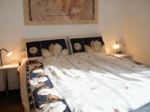 a bed with white sheets and flowers on it at Nordseeferienbungalow in Butjadingen
