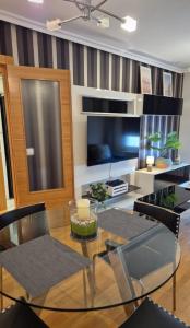 a dining room with a glass table and chairs at LUMARE LUANCO - A 5 min de la playa a pie - Parking incluido in Luanco