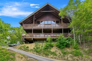 a large wooden house on a hill with a road at Above It All #38 by Venture Smoky Mountains in Sevierville