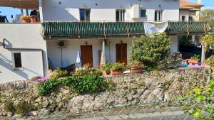 a house on a rock wall with potted plants at Il fortino affittacamere in Porto Santo Stefano