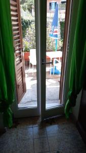 an open door leading to a patio with an umbrella at Il fortino affittacamere in Porto Santo Stefano