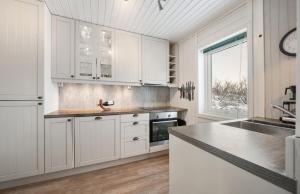 a kitchen with white cabinets and a counter top at Hytte Lødingen Vestbygd, når Lofoten, med utsikt in Lødingen