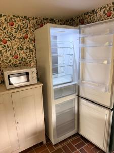 a refrigerator with its door open next to a microwave at Gästis in Borrby