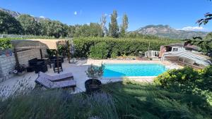 a backyard with a swimming pool and a house at Les Freds in Ventavon