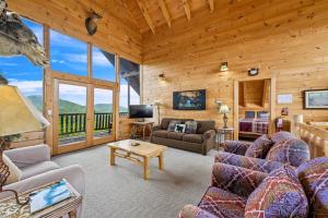 a living room with couches and a table in a cabin at Above It All #38 by Venture Smoky Mountains in Sevierville