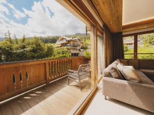 a living room with a couch on a balcony at Mountain Lodge Leogang-Premium Apartment, Balkon, Bergblick, Kamin, Sauna in Leogang