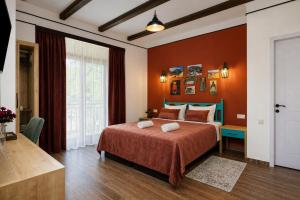 a bedroom with a large bed with orange walls at Pesvebi Design Hotel and Cellar in Borjomi +31 photos