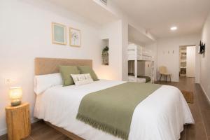 a bedroom with a large white bed with a green blanket at Xena Abeto by BeValle in Panticosa