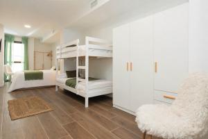 a bedroom with two bunk beds and a chair at Xena Abeto by BeValle in Panticosa