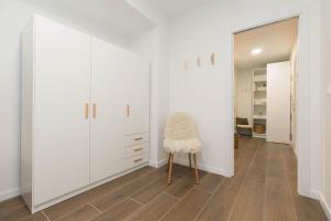 a dressing room with white cabinets and a stool at Xena Abeto by BeValle in Panticosa +24 photos