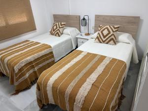 two beds in a hotel room withskirts at Gilarez in Estepona