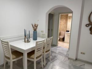 a white dining room with a white table and chairs at Gilarez in Estepona +11 photos