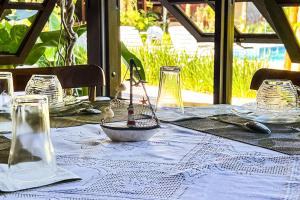 a table with a blue table cloth and glasses on it at VELINN Pousada Recanto dos Tangaras in Juquei