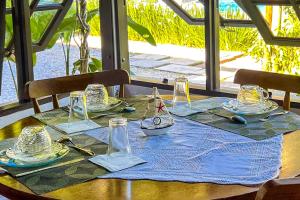 a table with a blue table cloth and glasses on it at VELINN Pousada Recanto dos Tangaras in Juquei