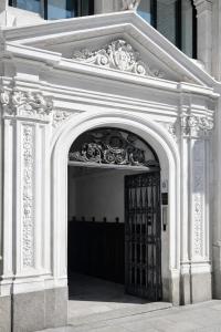 a white archway with a black gate in a building at Hostal Luxury Green Madrid Gran Vía in Madrid