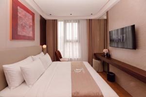 a hotel room with a bed and a television at The Pathway Sầm Sơn in Sầm Sơn
