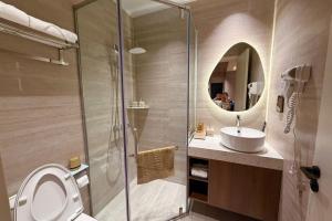 a bathroom with a toilet and a sink and a mirror at The Pathway Sầm Sơn in Sầm Sơn