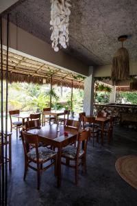 a restaurant with wooden tables and chairs and a chandelier at Pura Vida Hotel in Itarema