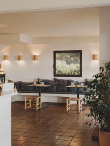 a room with a couch and tables and a window at Hotel Es Blau Des Nord in Colonia de Sant Pere