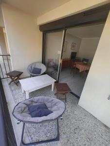 a room with a bed and a table and chairs at T4 proche de la plage & du centre in LʼÎle-Rousse