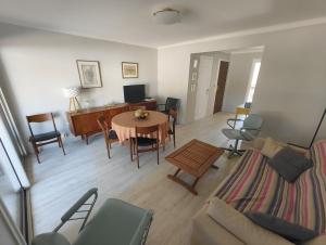 a living room with a table and a couch at T4 proche de la plage & du centre in LʼÎle-Rousse