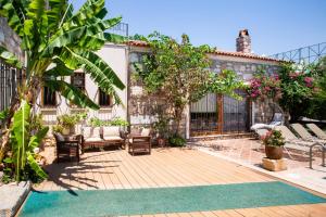 a backyard with a wooden deck with chairs and a house at Villa Mandarin by Important Group Travel in Bitez