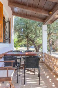 a patio with a table and chairs on a porch at Zanteva-Cottages in Vasilikos