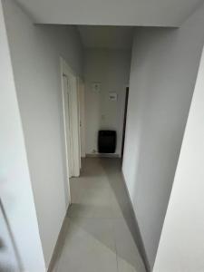 an empty hallway in a white room with a television at Soles de Pergamino in Pergamino +7 photos