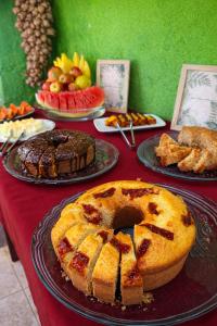 a table with different types of cakes and desserts at Pousada Sítio Xodó in Santana do Riacho