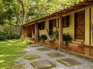 a house with a stone walkway in the yard at Pousada Sítio Xodó in Santana do Riacho +8 photos