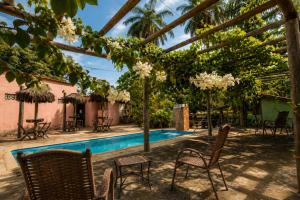 a patio with chairs and a swimming pool at Pousada Sítio Xodó in Santana do Riacho