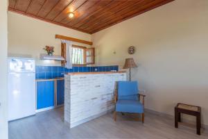 a kitchen with blue cabinets and a blue chair at Zanteva-Cottages in Vasilikos