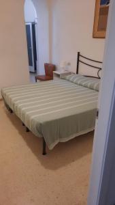 a large bed in a room with a chair at Il fortino affittacamere in Porto Santo Stefano