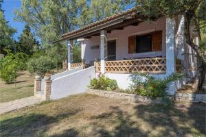 a house with a porch and a fence at Zanteva-Cottages in Vasilikos