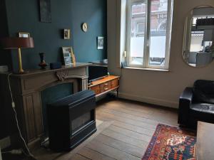 a living room with a fireplace and a couch at Urban Maghin in Liège