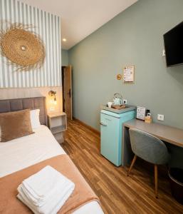 a hotel room with a bed and a desk and a computer at Hostal Luxury Green Madrid Gran Vía in Madrid +25 photos
