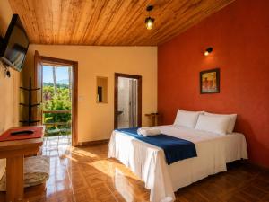 a bedroom with a bed in a room with orange walls at Pousada Sítio Xodó in Santana do Riacho