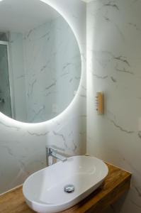 a white bathroom with a sink and a mirror at Contact Hôtel Fontenay le Comte in Fontenay-le-Comte