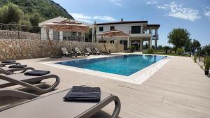 a villa with a swimming pool in front of a house at Villa Adria Heights in Pečurice