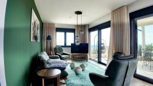 a living room with green walls and chairs and a television at Villa Adria Heights in Pečurice