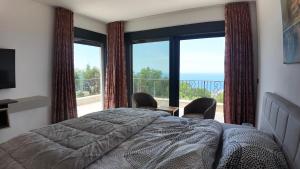 a bedroom with a bed and a view of the ocean at Villa Adria Heights in Pečurice +25 photos
