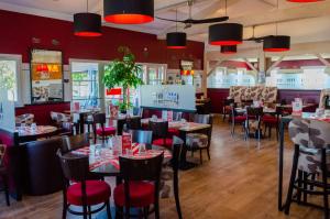 a restaurant with tables and chairs and red walls at Contact Hôtel Fontenay le Comte in Fontenay-le-Comte +9 photos