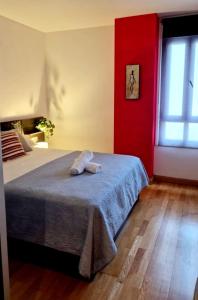 a bedroom with a bed with a towel on it at LUMARE LUANCO - A 5 min de la playa a pie - Parking incluido in Luanco